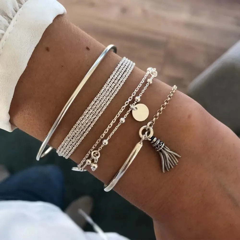 Set of 6 round bead bracelets with flower tassels, adjustable with geometric leaf shape.