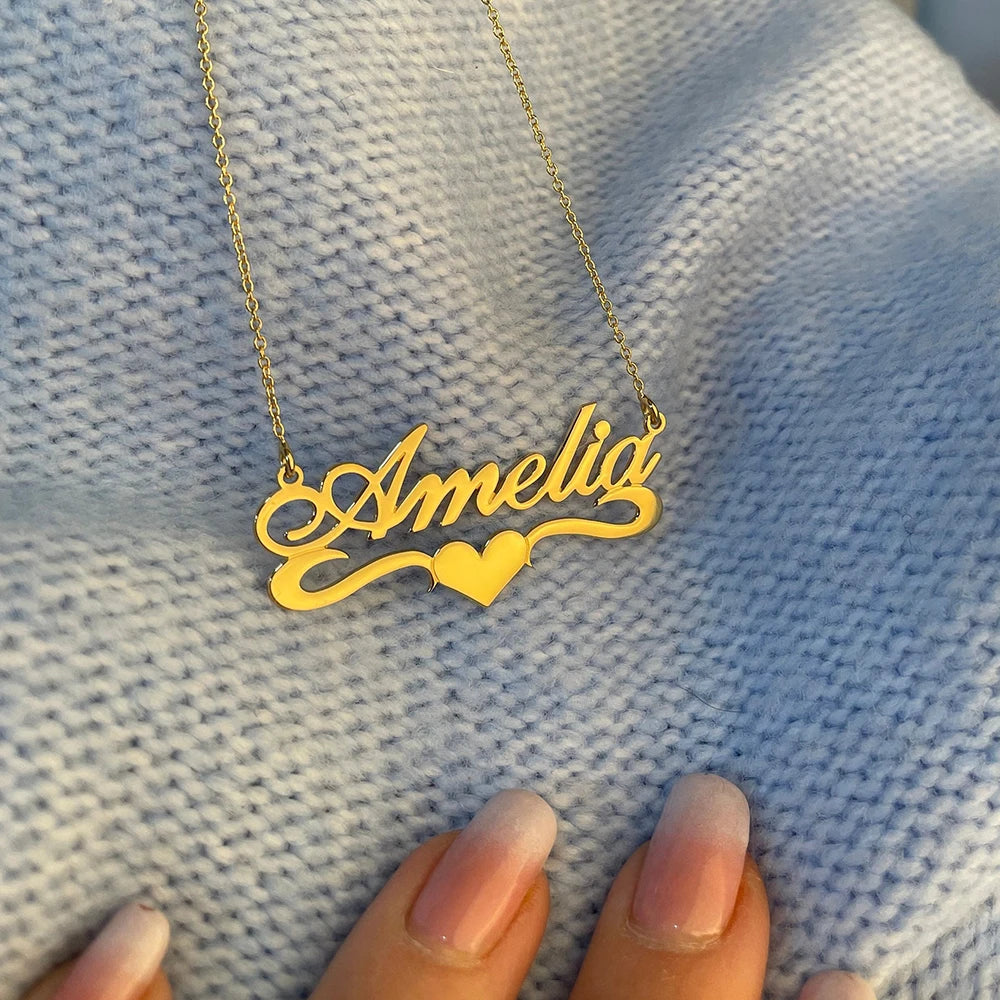 Personalized name plate necklaces with heart detail and stainless steel chain choker.